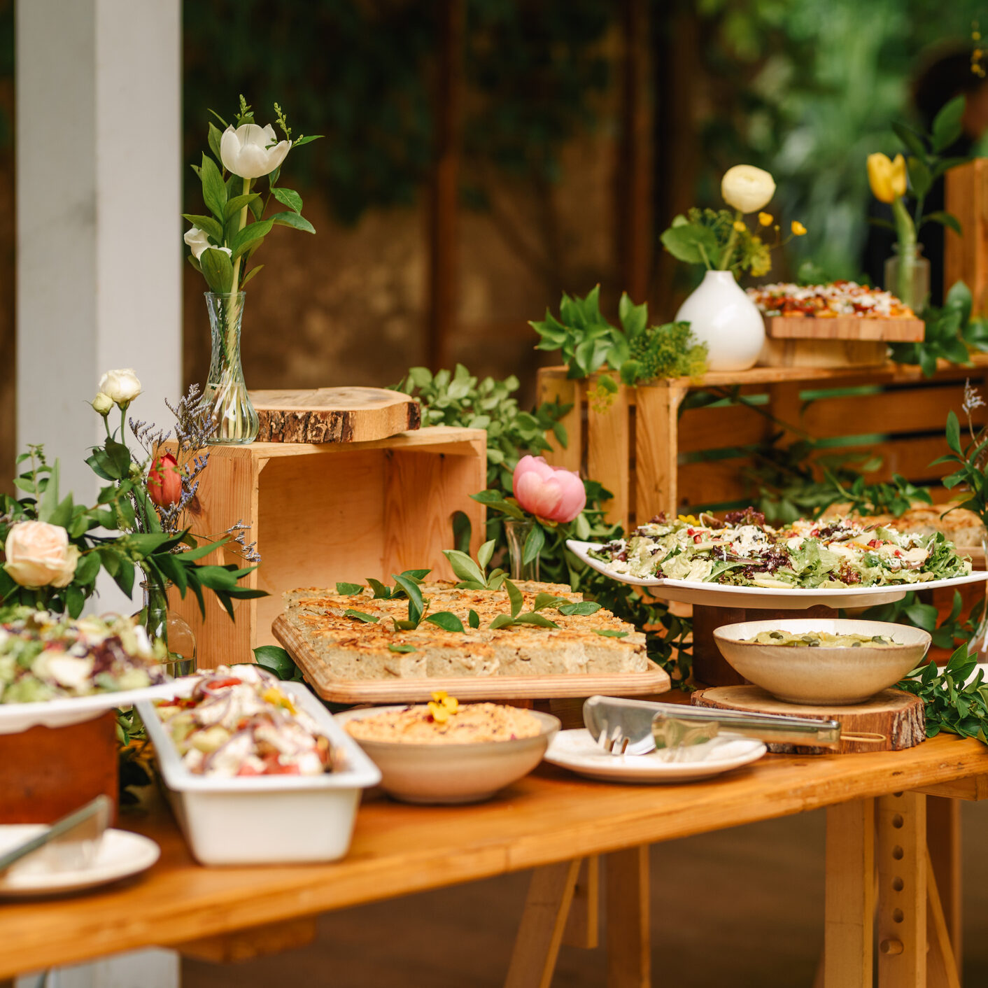 Decorative buffet setup with wooden crates and greenery.